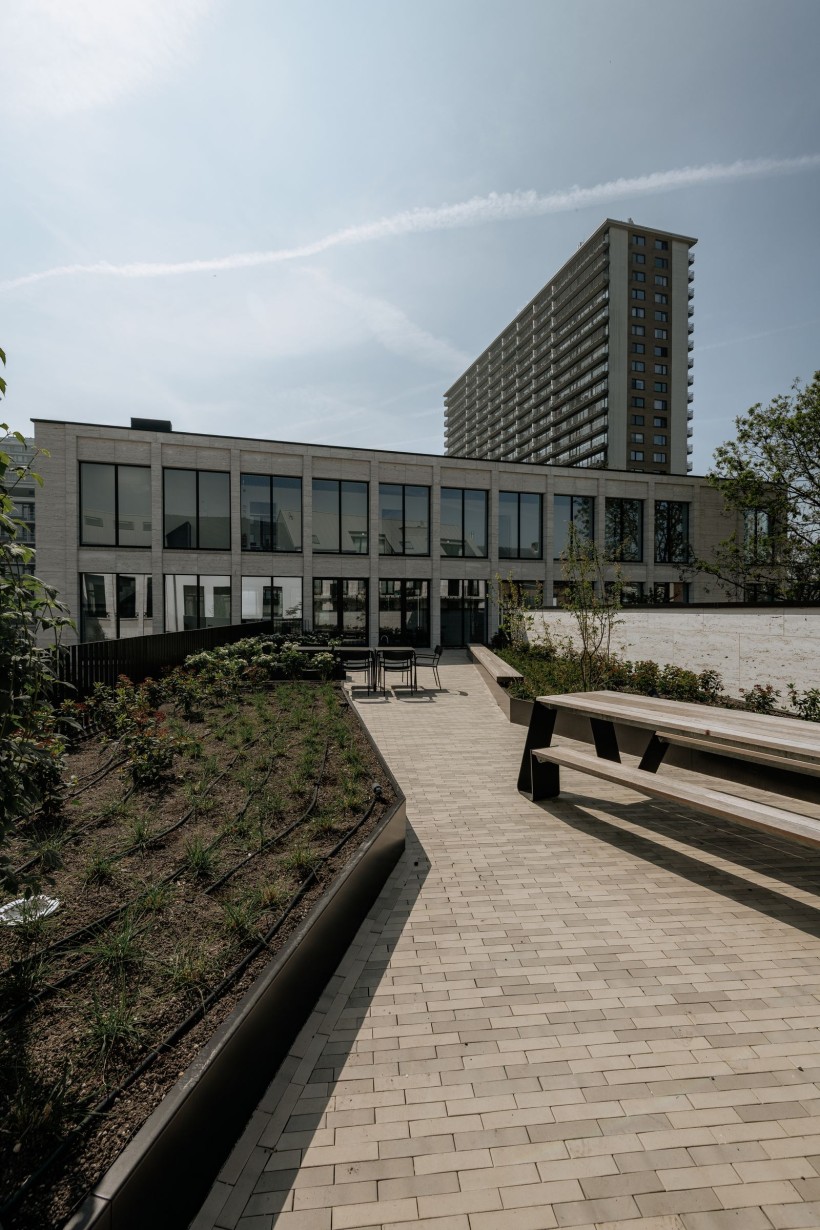Terras met picknicktafel en beplanting achter het kantoor